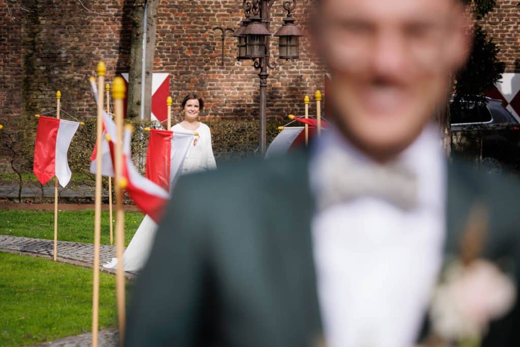 First Look. Ein Brautpaar in Wesel trifft sich zum ersten Mal vor der kirchlichen Trauung, festgehalten von einem Hochzeitsfotografen in Wesel