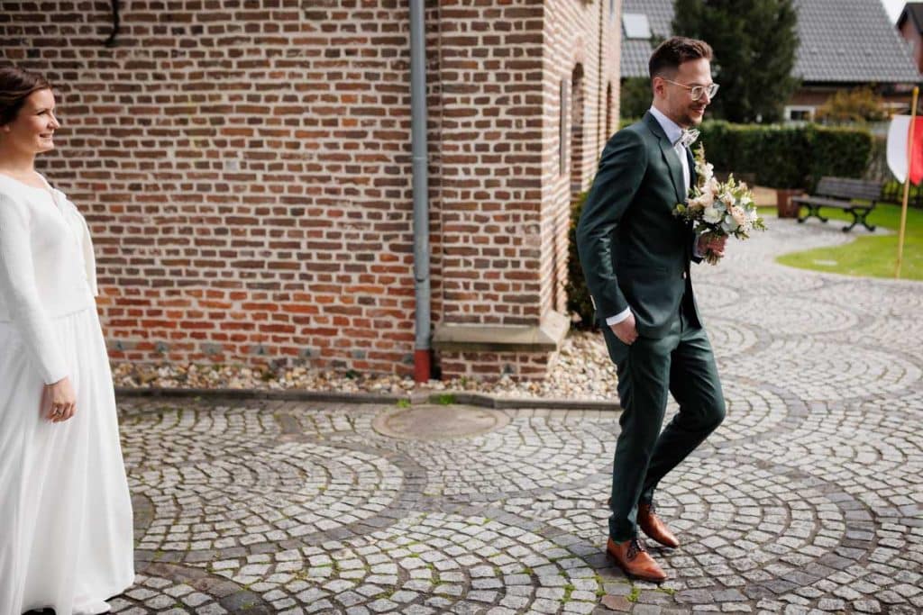 First Look. Ein Brautpaar in Wesel trifft sich zum ersten Mal vor der kirchlichen Trauung, festgehalten von einem Hochzeitsfotografen in Wesel