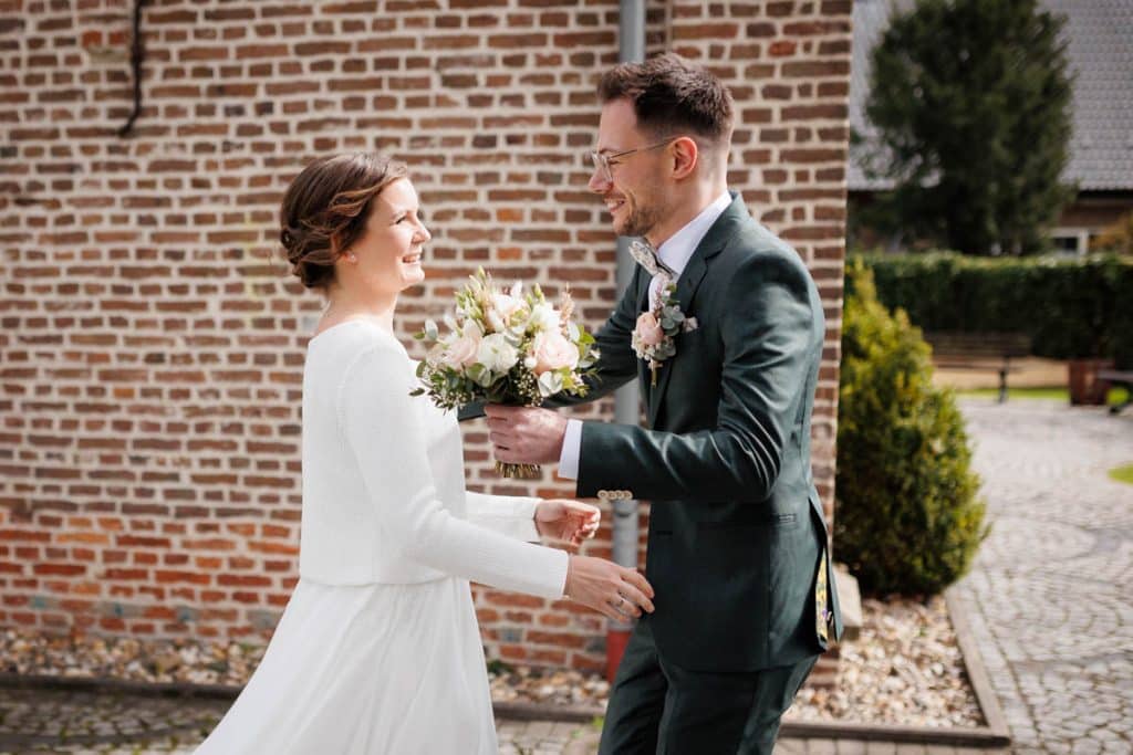 First Look. Ein Brautpaar in Wesel trifft sich zum ersten Mal vor der kirchlichen Trauung, festgehalten von einem Hochzeitsfotografen in Wesel
