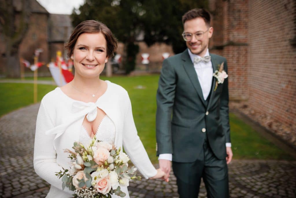 First Look. Ein Brautpaar in Wesel trifft sich zum ersten Mal vor der kirchlichen Trauung, festgehalten von einem Hochzeitsfotografen in Wesel