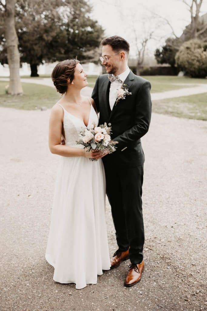 Romantisches Hochzeitsfotoshooting am Landhaus Ridder in Wesel-Hamminkeln: Das Brautpaar posiert in der idyllischen Parkanlage der beliebten Hochzeitslocation. Die Braut trägt ein elegantes Spitzenkleid, der Bräutigam einen festlichen Anzug. Dieses Foto zeigt die natürliche und authentische Hochzeitsfotografie beim Landhaus Ridder in Wesel-Hamminkeln