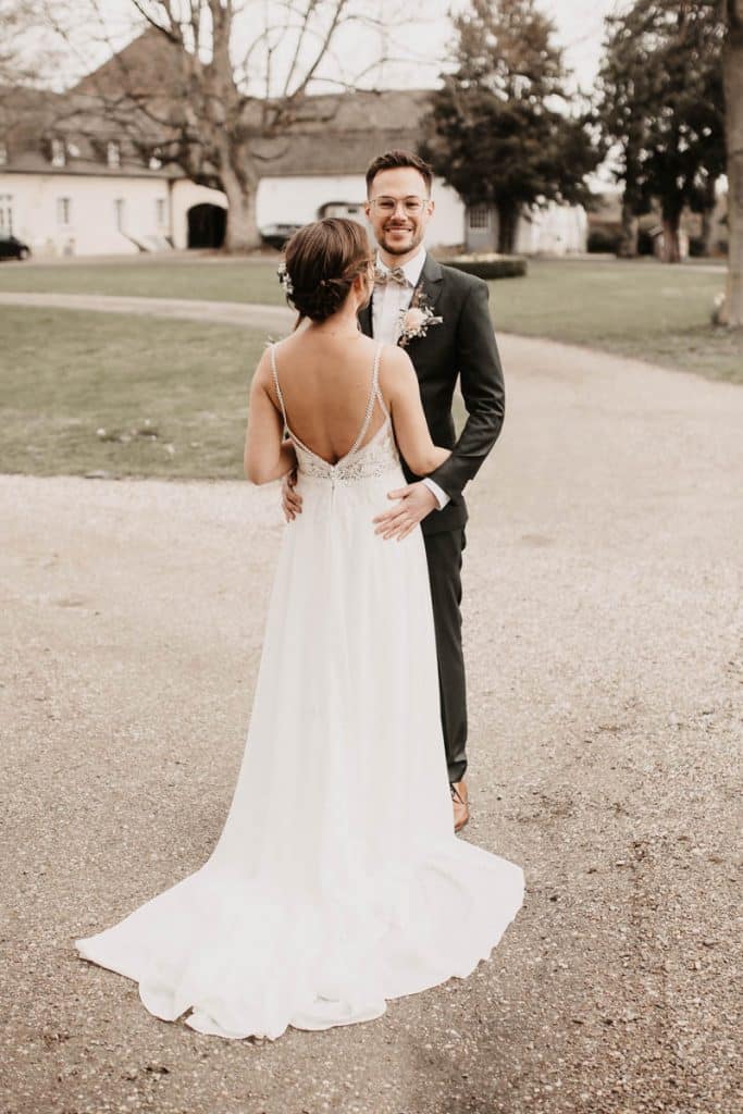 Romantisches Hochzeitsfotoshooting am Landhaus Ridder in Wesel-Hamminkeln: Das Brautpaar posiert in der idyllischen Parkanlage der beliebten Hochzeitslocation. Die Braut trägt ein elegantes Spitzenkleid, der Bräutigam einen festlichen Anzug. Dieses Foto zeigt die natürliche und authentische Hochzeitsfotografie beim Landhaus Ridder in Wesel-Hamminkeln