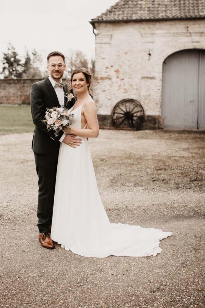 Romantisches Hochzeitsfotoshooting am Landhaus Ridder in Wesel-Hamminkeln: Das Brautpaar posiert in der idyllischen Parkanlage der beliebten Hochzeitslocation. Die Braut trägt ein elegantes Spitzenkleid, der Bräutigam einen festlichen Anzug. Dieses Foto zeigt die natürliche und authentische Hochzeitsfotografie beim Landhaus Ridder in Wesel-Hamminkeln