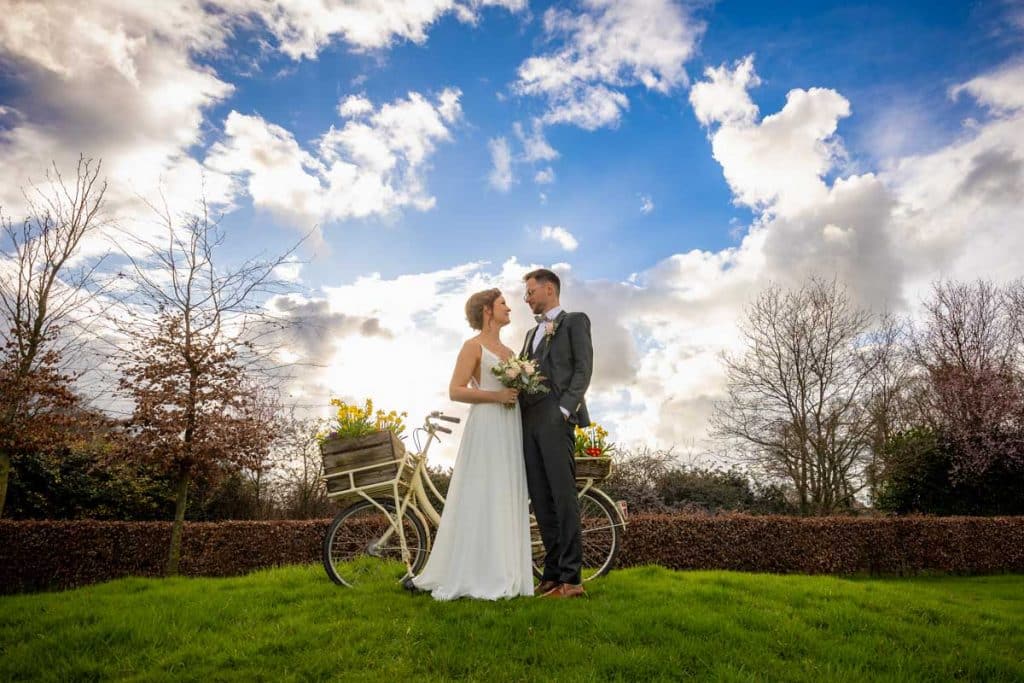 Romantisches Hochzeitsfotoshooting am Landhaus Ridder in Wesel-Hamminkeln: Das Brautpaar posiert in der idyllischen Parkanlage der beliebten Hochzeitslocation. Die Braut trägt ein elegantes Spitzenkleid, der Bräutigam einen festlichen Anzug. Dieses Foto zeigt die natürliche und authentische Hochzeitsfotografie beim Landhaus Ridder in Wesel-Hamminkeln