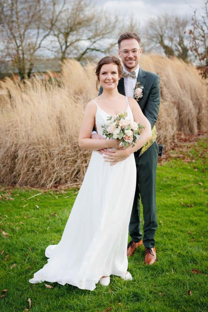Romantisches Hochzeitsfotoshooting am Landhaus Ridder in Wesel-Hamminkeln: Das Brautpaar posiert in der idyllischen Parkanlage der beliebten Hochzeitslocation. Die Braut trägt ein elegantes Spitzenkleid, der Bräutigam einen festlichen Anzug. Dieses Foto zeigt die natürliche und authentische Hochzeitsfotografie beim Landhaus Ridder in Wesel-Hamminkeln