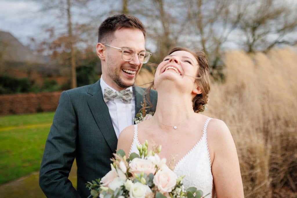 Romantisches Hochzeitsfotoshooting am Landhaus Ridder in Wesel-Hamminkeln: Das Brautpaar posiert in der idyllischen Parkanlage der beliebten Hochzeitslocation. Die Braut trägt ein elegantes Spitzenkleid, der Bräutigam einen festlichen Anzug. Dieses Foto zeigt die natürliche und authentische Hochzeitsfotografie beim Landhaus Ridder in Wesel-Hamminkeln