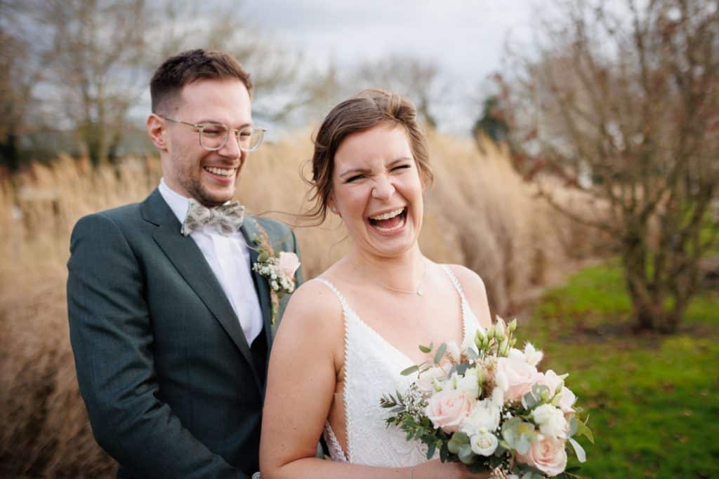 Romantisches Hochzeitsfotoshooting am Landhaus Ridder in Wesel-Hamminkeln: Das Brautpaar posiert in der idyllischen Parkanlage der beliebten Hochzeitslocation. Die Braut trägt ein elegantes Spitzenkleid, der Bräutigam einen festlichen Anzug. Dieses Foto zeigt die natürliche und authentische Hochzeitsfotografie beim Landhaus Ridder in Wesel-Hamminkeln