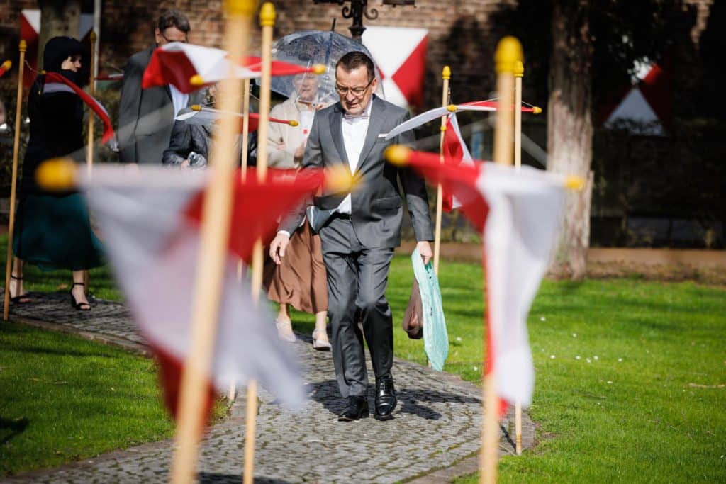Emotionaler Moment bei der kirchlichen Trauung in Wesel: Das Brautpaar steht gemeinsam am Altar, die Braut im weißen Spitzenkleid mit Schleier, der Bräutigam im eleganten Anzug. Gäste verfolgen die Zeremonie in der Kirche aufmerksam. Dieses authentische Hochzeitsfoto hält die besonderen Augenblicke fest und zeigt die lebendige Hochzeitsfotografie in Wesel.