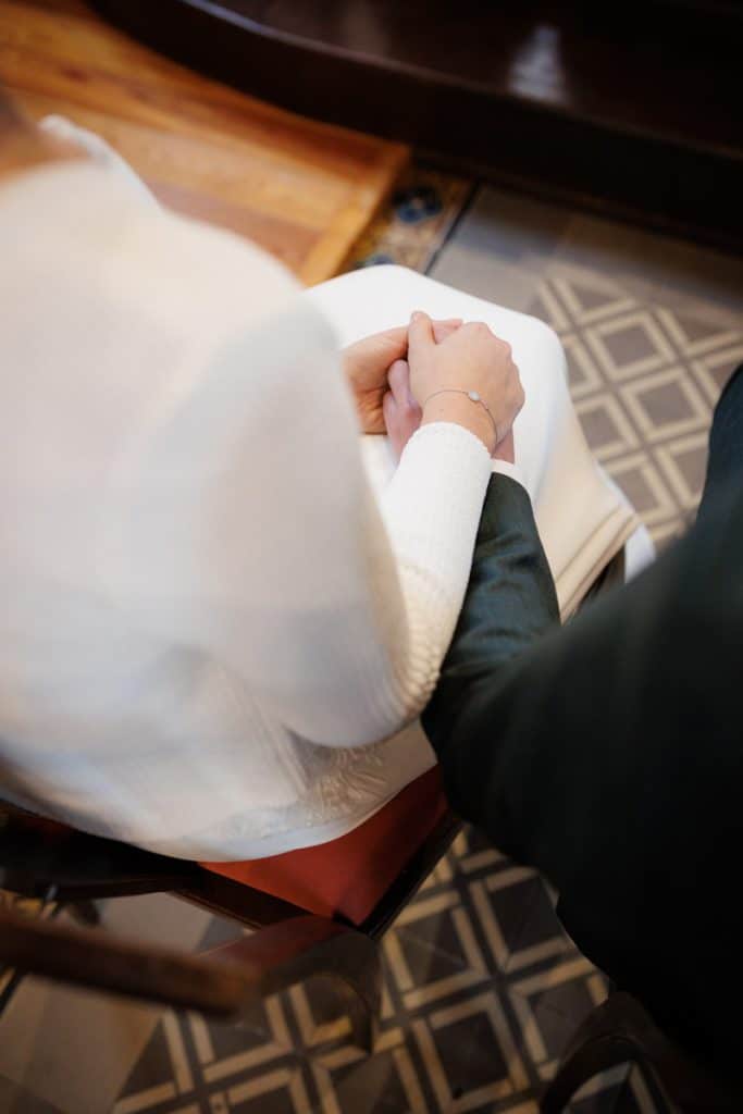 Emotionaler Moment bei der kirchlichen Trauung in Wesel: Das Brautpaar steht gemeinsam am Altar, die Braut im weißen Spitzenkleid mit Schleier, der Bräutigam im eleganten Anzug. Gäste verfolgen die Zeremonie in der Kirche aufmerksam. Dieses authentische Hochzeitsfoto hält die besonderen Augenblicke fest und zeigt die lebendige Hochzeitsfotografie in Wesel.
