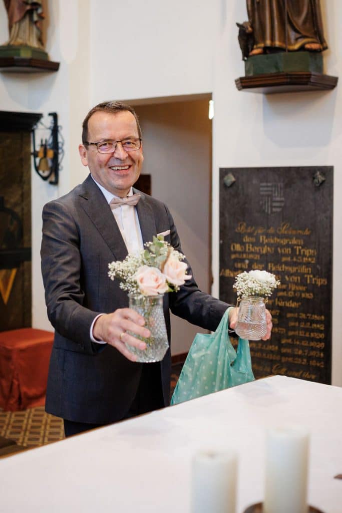 Emotionaler Moment bei der kirchlichen Trauung in Wesel: Das Brautpaar steht gemeinsam am Altar, die Braut im weißen Spitzenkleid mit Schleier, der Bräutigam im eleganten Anzug. Gäste verfolgen die Zeremonie in der Kirche aufmerksam. Dieses authentische Hochzeitsfoto hält die besonderen Augenblicke fest und zeigt die lebendige Hochzeitsfotografie in Wesel.