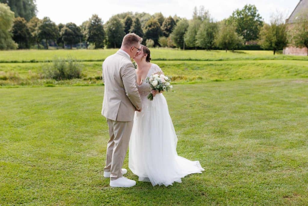 Emotionaler First Look von Braut und Bräutigam auf Schloss Diersfordt in Wesel: Der Bräutigam sieht seine Braut zum ersten Mal im weißen Kleid. Die historische Schlosskulisse sorgt für eine romantische Atmosphäre. Festgehalten vom Hochzeitsfotograf Wesel.
