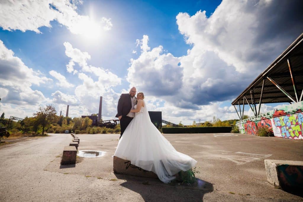 Fotoshooting im Landschaftspark Duisburg Nord: Das Brautpaar posiert in der einzigartigen Industriekulisse zwischen alten Stahlkonstruktionen und grüner Natur. Kreative und emotionale Hochzeitsfotos voller Kontraste, festgehalten vom Hochzeitsfotograf Duisburg.