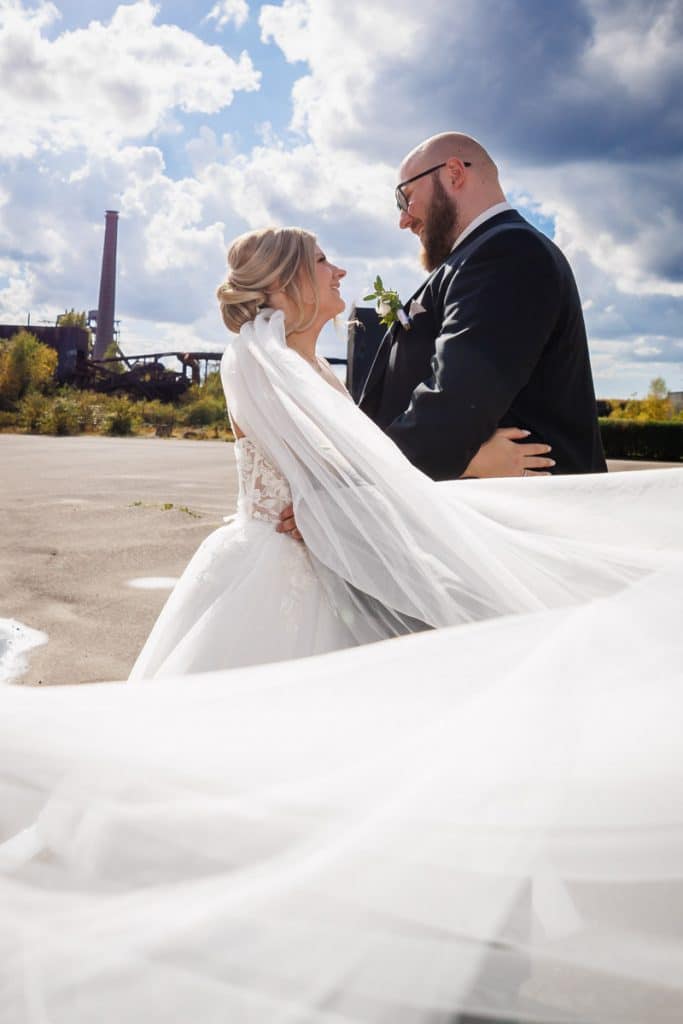 Fotoshooting im Landschaftspark Duisburg Nord: Das Brautpaar posiert in der einzigartigen Industriekulisse zwischen alten Stahlkonstruktionen und grüner Natur. Kreative und emotionale Hochzeitsfotos voller Kontraste, festgehalten vom Hochzeitsfotograf Duisburg.