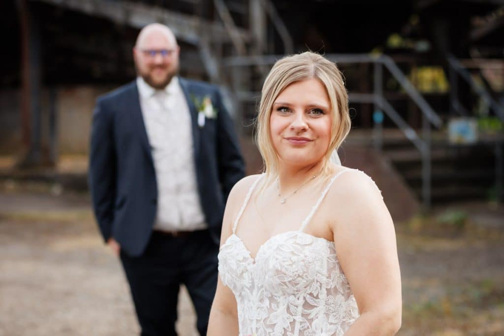 Fotoshooting im Landschaftspark Duisburg Nord: Das Brautpaar posiert in der einzigartigen Industriekulisse zwischen alten Stahlkonstruktionen und grüner Natur. Kreative und emotionale Hochzeitsfotos voller Kontraste, festgehalten vom Hochzeitsfotograf Duisburg.