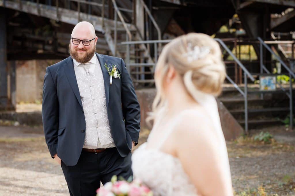 Fotoshooting im Landschaftspark Duisburg Nord: Das Brautpaar posiert in der einzigartigen Industriekulisse zwischen alten Stahlkonstruktionen und grüner Natur. Kreative und emotionale Hochzeitsfotos voller Kontraste, festgehalten vom Hochzeitsfotograf Duisburg.