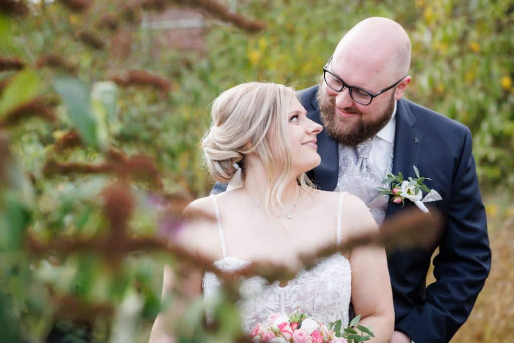 Fotoshooting im Landschaftspark Duisburg Nord: Das Brautpaar posiert in der einzigartigen Industriekulisse zwischen alten Stahlkonstruktionen und grüner Natur. Kreative und emotionale Hochzeitsfotos voller Kontraste, festgehalten vom Hochzeitsfotograf Duisburg.