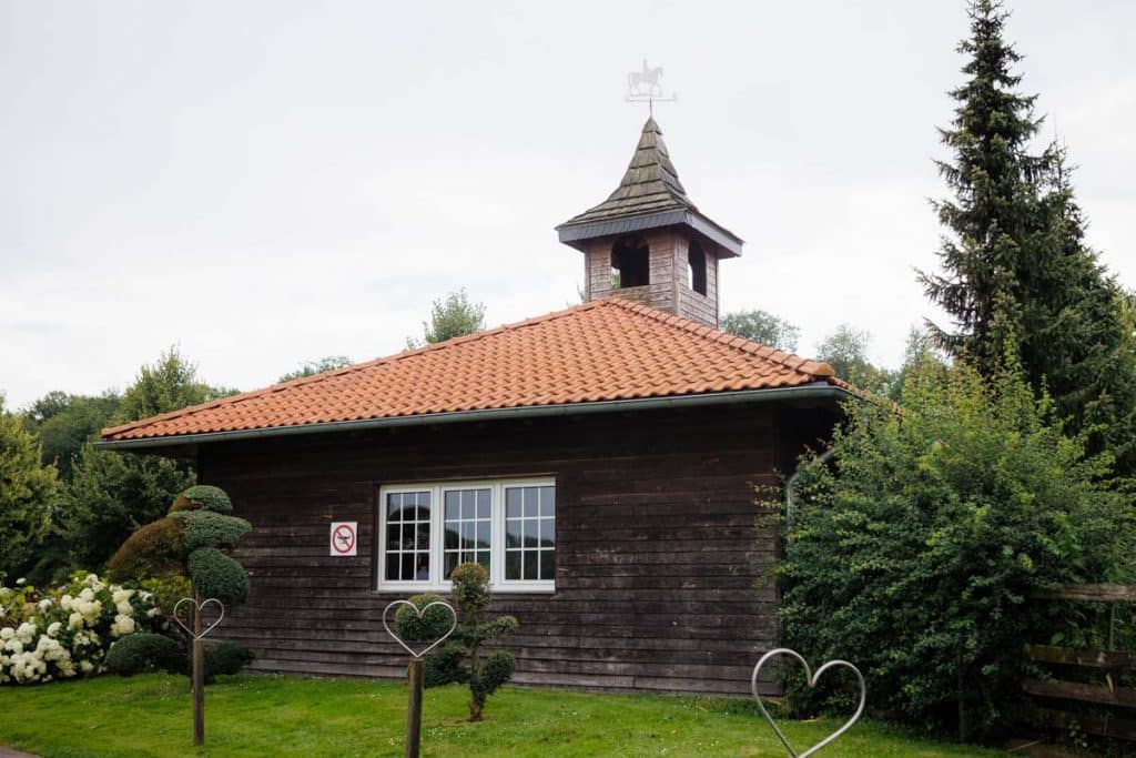 Emotionale freie Trauung im Innenbereich des Landgut Hochwald in Sonsbeck: Das Brautpaar gibt sich vor Familie und Freunden das Ja-Wort. Kerzen, Blumenarrangements und stimmungsvolles Licht sorgen für eine romantische Atmosphäre. Besondere Augenblicke festgehalten vom Hochzeitsfotograf Niederrhein.