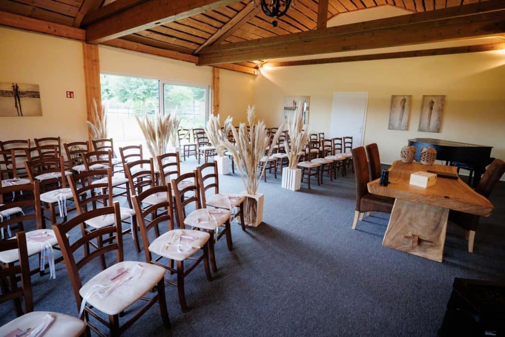 Emotionale freie Trauung im Innenbereich des Landgut Hochwald in Sonsbeck: Das Brautpaar gibt sich vor Familie und Freunden das Ja-Wort. Kerzen, Blumenarrangements und stimmungsvolles Licht sorgen für eine romantische Atmosphäre. Besondere Augenblicke festgehalten vom Hochzeitsfotograf Niederrhein.