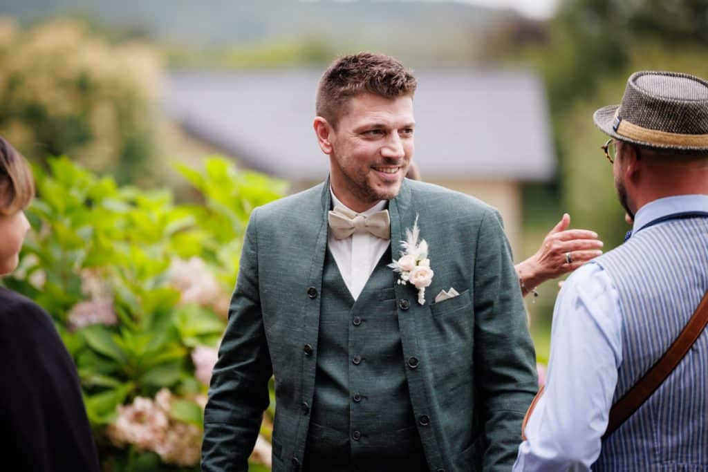 Emotionale freie Trauung im Innenbereich des Landgut Hochwald in Sonsbeck: Das Brautpaar gibt sich vor Familie und Freunden das Ja-Wort. Kerzen, Blumenarrangements und stimmungsvolles Licht sorgen für eine romantische Atmosphäre. Besondere Augenblicke festgehalten vom Hochzeitsfotograf Niederrhein.