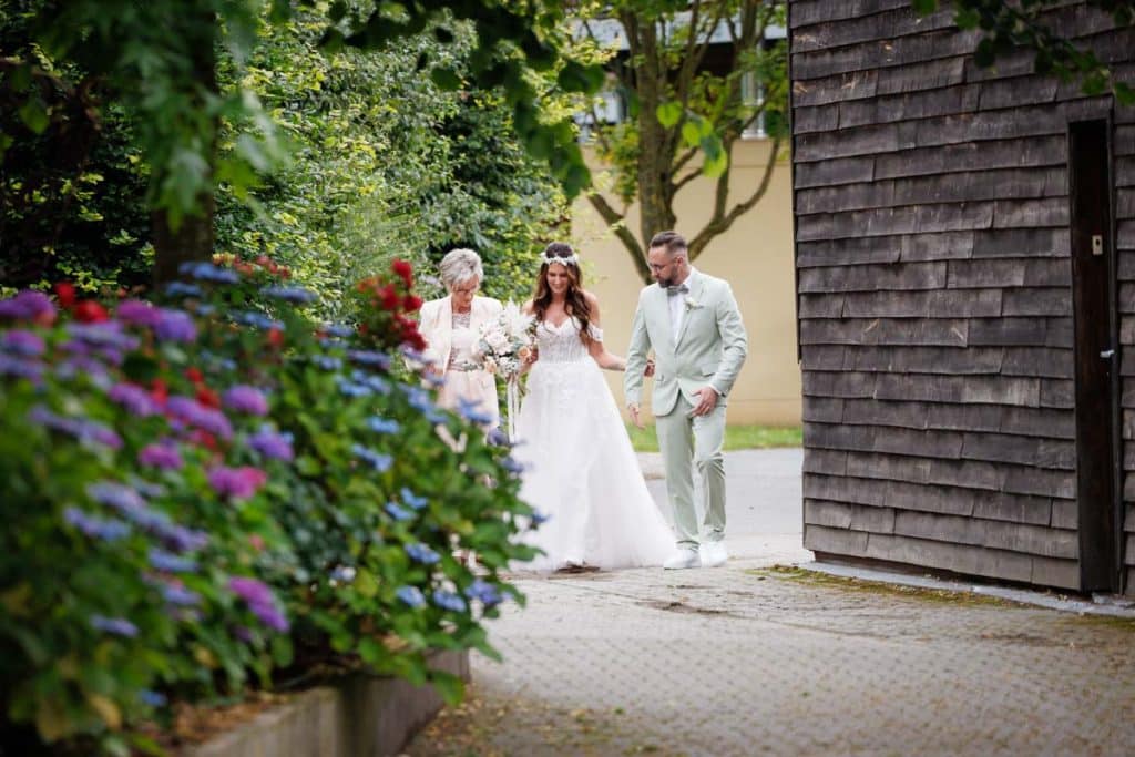 Emotionale freie Trauung im Innenbereich des Landgut Hochwald in Sonsbeck: Das Brautpaar gibt sich vor Familie und Freunden das Ja-Wort. Kerzen, Blumenarrangements und stimmungsvolles Licht sorgen für eine romantische Atmosphäre. Besondere Augenblicke festgehalten vom Hochzeitsfotograf Niederrhein.