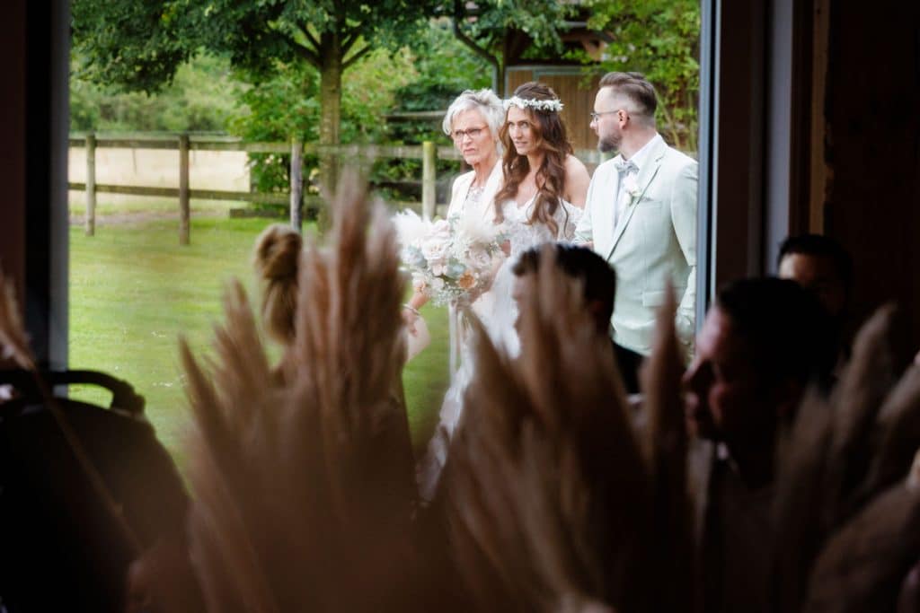 Emotionale freie Trauung im Innenbereich des Landgut Hochwald in Sonsbeck: Das Brautpaar gibt sich vor Familie und Freunden das Ja-Wort. Kerzen, Blumenarrangements und stimmungsvolles Licht sorgen für eine romantische Atmosphäre. Besondere Augenblicke festgehalten vom Hochzeitsfotograf Niederrhein.