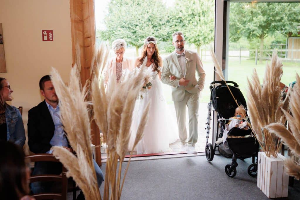 Emotionale freie Trauung im Innenbereich des Landgut Hochwald in Sonsbeck: Das Brautpaar gibt sich vor Familie und Freunden das Ja-Wort. Kerzen, Blumenarrangements und stimmungsvolles Licht sorgen für eine romantische Atmosphäre. Besondere Augenblicke festgehalten vom Hochzeitsfotograf Niederrhein.