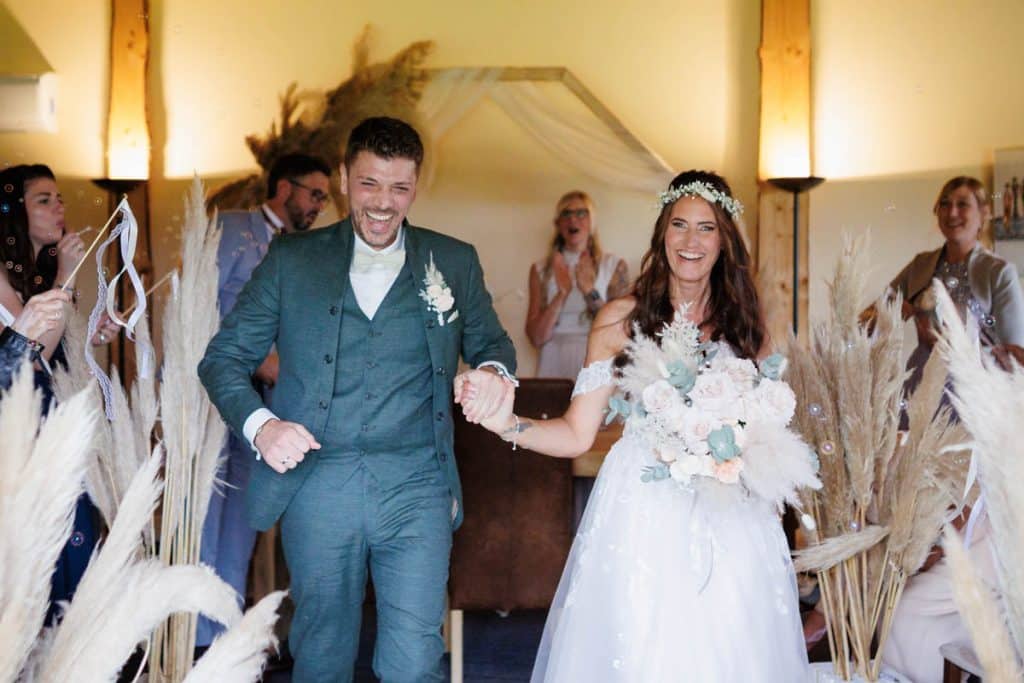 Emotionale freie Trauung im Innenbereich des Landgut Hochwald in Sonsbeck: Das Brautpaar gibt sich vor Familie und Freunden das Ja-Wort. Kerzen, Blumenarrangements und stimmungsvolles Licht sorgen für eine romantische Atmosphäre. Besondere Augenblicke festgehalten vom Hochzeitsfotograf Niederrhein.