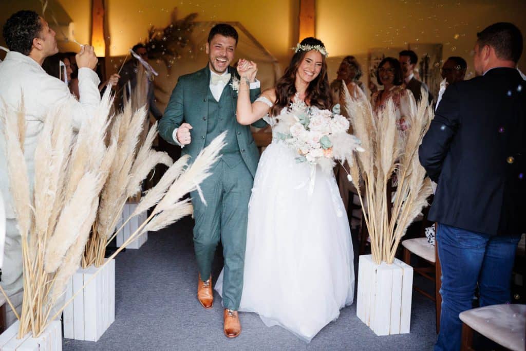 Emotionale freie Trauung im Innenbereich des Landgut Hochwald in Sonsbeck: Das Brautpaar gibt sich vor Familie und Freunden das Ja-Wort. Kerzen, Blumenarrangements und stimmungsvolles Licht sorgen für eine romantische Atmosphäre. Besondere Augenblicke festgehalten vom Hochzeitsfotograf Niederrhein.