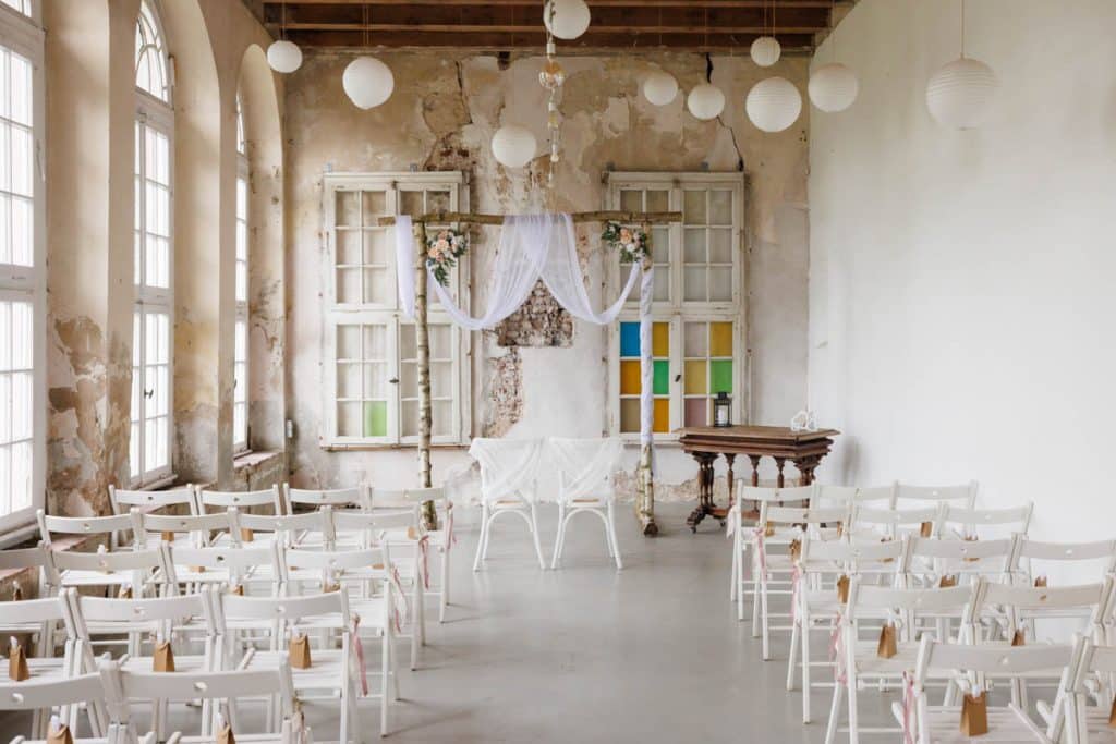 Freie Trauung in der stilvollen Orangerie von Schloss Diersfordt in Wesel: Das Brautpaar gibt sich vor Familie und Freunden das Ja-Wort in eleganter, lichtdurchfluteter Umgebung. Blumendekoration, romantisches Ambiente und die besondere Location machen diesen Moment einzigartig. Festgehalten vom Hochzeitsfotograf Wesel.
