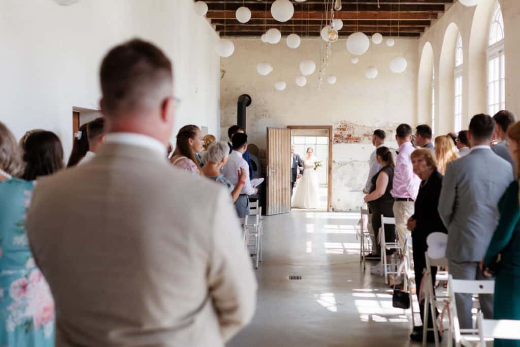 Freie Trauung in der stilvollen Orangerie von Schloss Diersfordt in Wesel: Das Brautpaar gibt sich vor Familie und Freunden das Ja-Wort in eleganter, lichtdurchfluteter Umgebung. Blumendekoration, romantisches Ambiente und die besondere Location machen diesen Moment einzigartig. Festgehalten vom Hochzeitsfotograf Wesel.