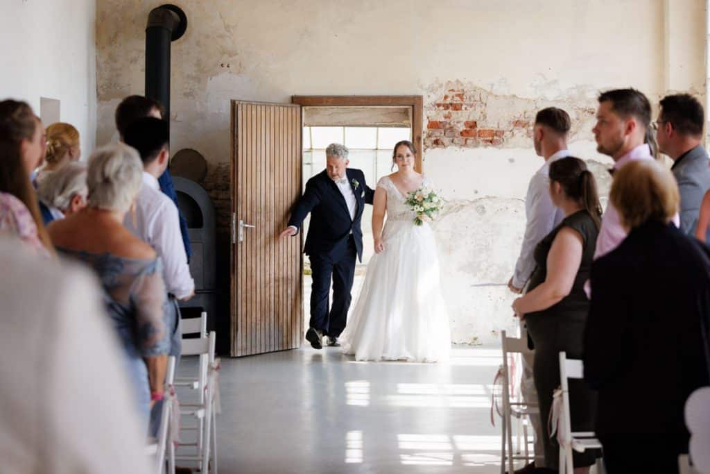 Freie Trauung in der stilvollen Orangerie von Schloss Diersfordt in Wesel: Das Brautpaar gibt sich vor Familie und Freunden das Ja-Wort in eleganter, lichtdurchfluteter Umgebung. Blumendekoration, romantisches Ambiente und die besondere Location machen diesen Moment einzigartig. Festgehalten vom Hochzeitsfotograf Wesel.