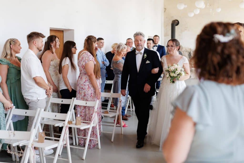 Freie Trauung in der stilvollen Orangerie von Schloss Diersfordt in Wesel: Das Brautpaar gibt sich vor Familie und Freunden das Ja-Wort in eleganter, lichtdurchfluteter Umgebung. Blumendekoration, romantisches Ambiente und die besondere Location machen diesen Moment einzigartig. Festgehalten vom Hochzeitsfotograf Wesel.
