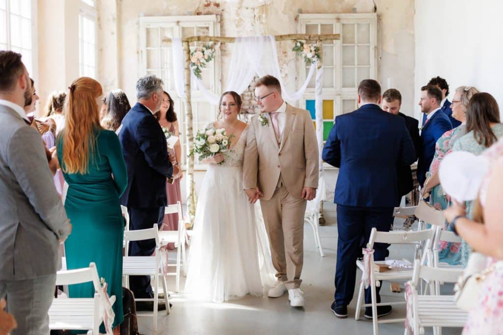 Freie Trauung in der stilvollen Orangerie von Schloss Diersfordt in Wesel: Das Brautpaar gibt sich vor Familie und Freunden das Ja-Wort in eleganter, lichtdurchfluteter Umgebung. Blumendekoration, romantisches Ambiente und die besondere Location machen diesen Moment einzigartig. Festgehalten vom Hochzeitsfotograf Wesel.