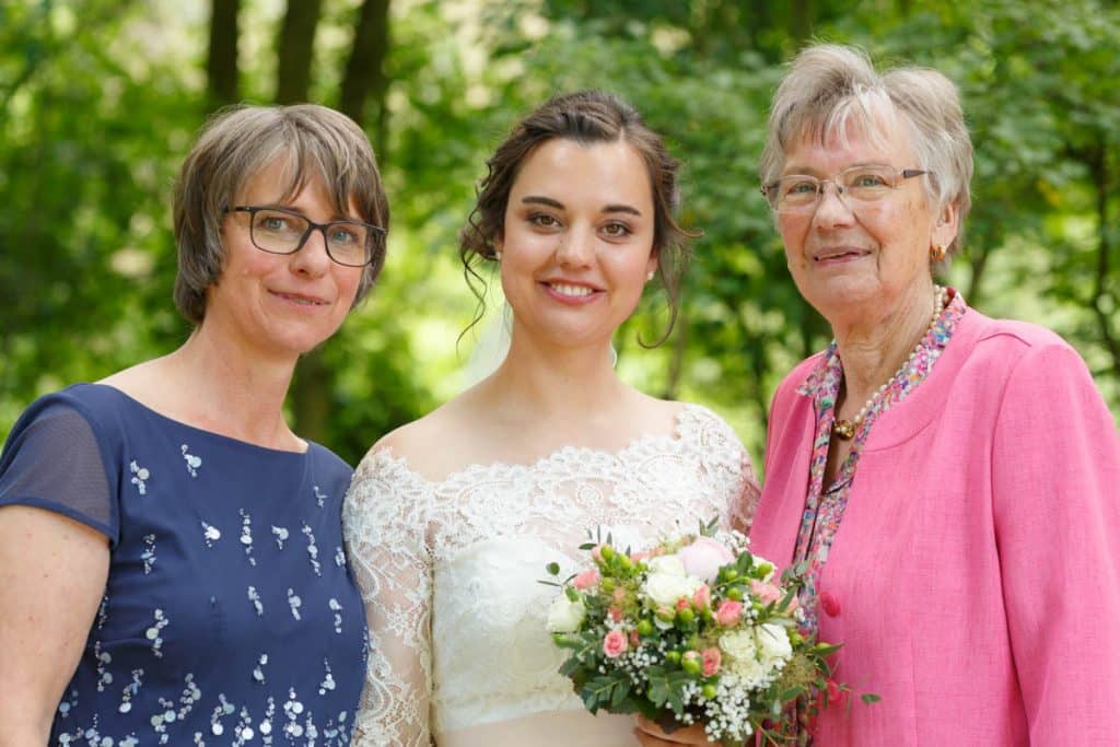Fröhliche Gruppenfotos nach der Hochzeit in Xanten: Das Brautpaar posiert mit Familie und Freunden vor der Kirche. Lächelnde Gesichter, elegante Outfits und die festliche Stimmung machen die Gruppenfotos zu einer bleibenden Erinnerung. Fotografiert vom Hochzeitsfotograf Xanten.