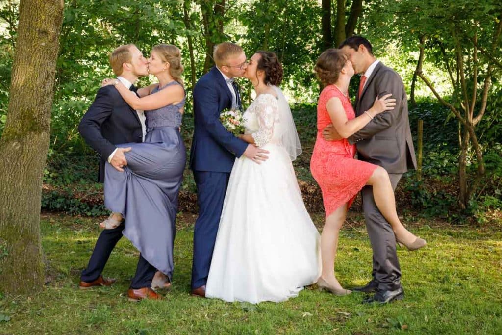 Fröhliche Gruppenfotos nach der Hochzeit in Xanten: Das Brautpaar posiert mit Familie und Freunden vor der Kirche. Lächelnde Gesichter, elegante Outfits und die festliche Stimmung machen die Gruppenfotos zu einer bleibenden Erinnerung. Fotografiert vom Hochzeitsfotograf Xanten.
