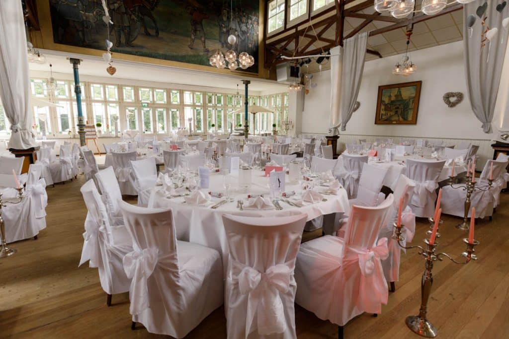 Stimmungsvolle Hochzeitsfeier im Alten Schützenhaus in Xanten: Das Brautpaar tanzt ausgelassen mit Familie und Freunden. Die festlich geschmückte Location, lachende Gäste und Musik schaffen eine lebendige Atmosphäre voller Emotionen. Dieses Foto zeigt die authentische Hochzeitsreportage vom Hochzeitsfotograf Xanten.
