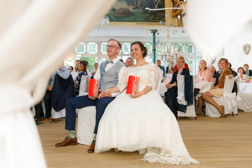 Stimmungsvolle Hochzeitsfeier im Alten Schützenhaus in Xanten: Das Brautpaar tanzt ausgelassen mit Familie und Freunden. Die festlich geschmückte Location, lachende Gäste und Musik schaffen eine lebendige Atmosphäre voller Emotionen. Dieses Foto zeigt die authentische Hochzeitsreportage vom Hochzeitsfotograf Xanten.