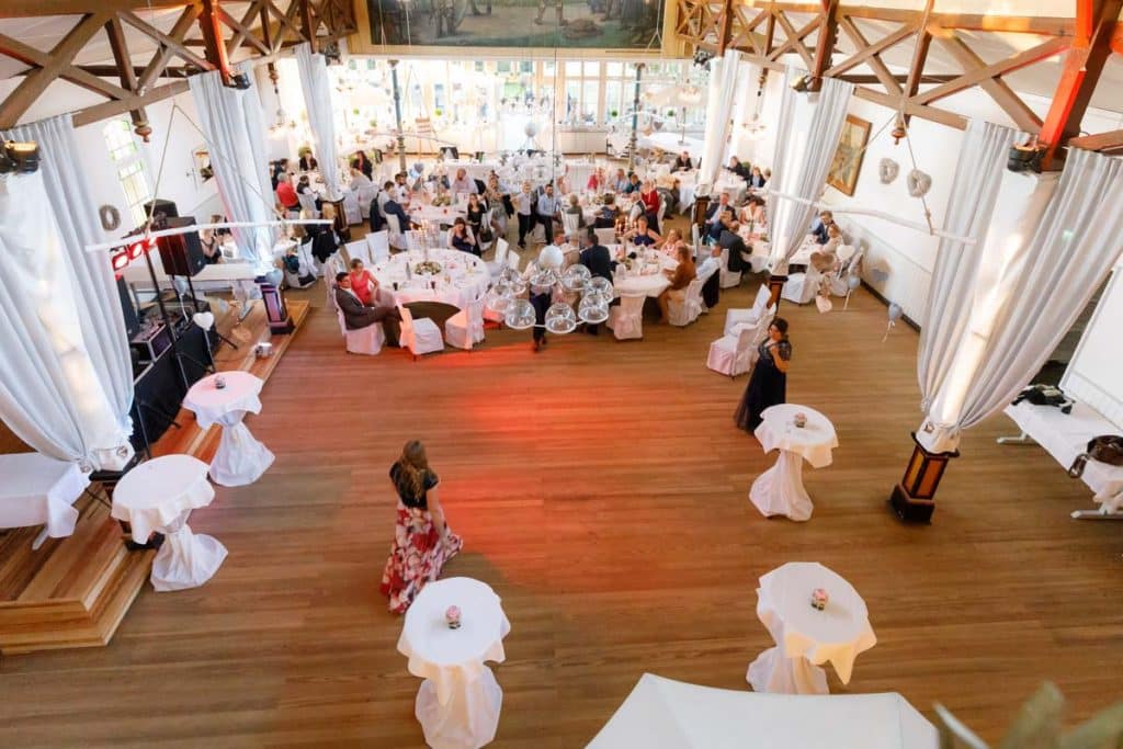 Stimmungsvolle Hochzeitsfeier im Alten Schützenhaus in Xanten: Das Brautpaar tanzt ausgelassen mit Familie und Freunden. Die festlich geschmückte Location, lachende Gäste und Musik schaffen eine lebendige Atmosphäre voller Emotionen. Dieses Foto zeigt die authentische Hochzeitsreportage vom Hochzeitsfotograf Xanten.