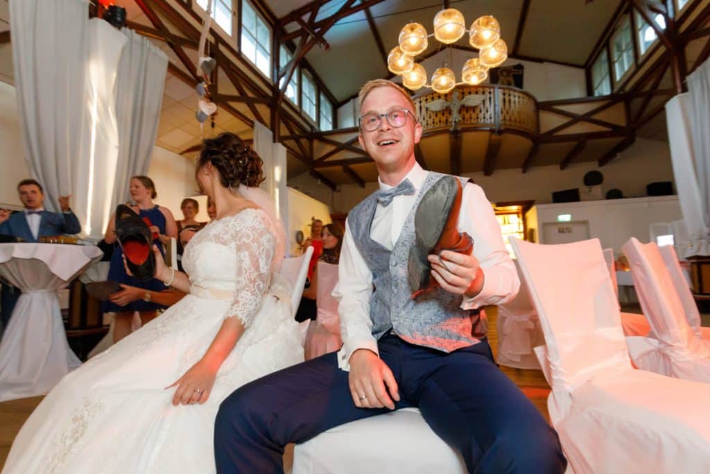 Stimmungsvolle Hochzeitsfeier im Alten Schützenhaus in Xanten: Das Brautpaar tanzt ausgelassen mit Familie und Freunden. Die festlich geschmückte Location, lachende Gäste und Musik schaffen eine lebendige Atmosphäre voller Emotionen. Dieses Foto zeigt die authentische Hochzeitsreportage vom Hochzeitsfotograf Xanten.