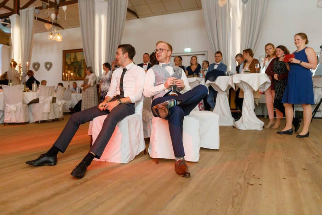 Stimmungsvolle Hochzeitsfeier im Alten Schützenhaus in Xanten: Das Brautpaar tanzt ausgelassen mit Familie und Freunden. Die festlich geschmückte Location, lachende Gäste und Musik schaffen eine lebendige Atmosphäre voller Emotionen. Dieses Foto zeigt die authentische Hochzeitsreportage vom Hochzeitsfotograf Xanten.