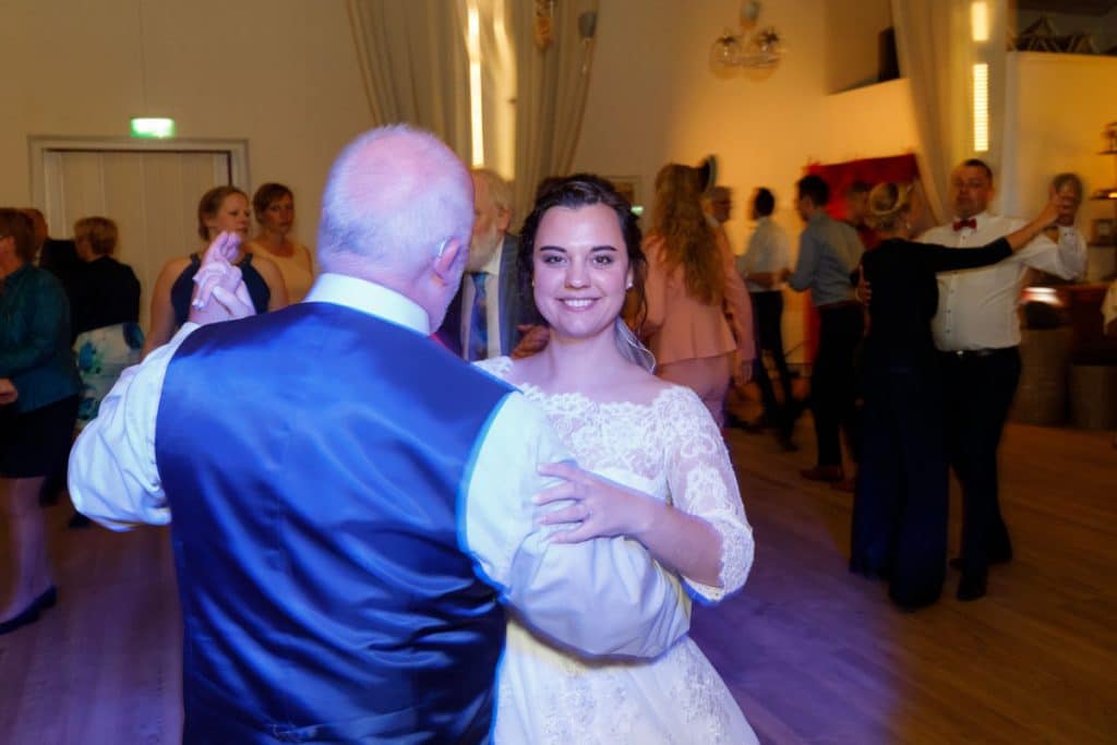 Stimmungsvolle Hochzeitsfeier im Alten Schützenhaus in Xanten: Das Brautpaar tanzt ausgelassen mit Familie und Freunden. Die festlich geschmückte Location, lachende Gäste und Musik schaffen eine lebendige Atmosphäre voller Emotionen. Dieses Foto zeigt die authentische Hochzeitsreportage vom Hochzeitsfotograf Xanten.