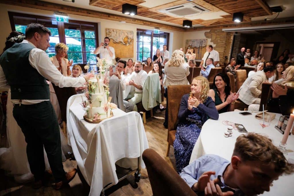 Lebhafte Hochzeitsfeier im Landgut Hochwald in Sonsbeck: Das Brautpaar tanzt ausgelassen mit Familie und Freunden, die Stimmung ist voller Freude und Energie. Die festlich dekorierte Location bietet den perfekten Rahmen für eine unvergessliche Feier, fotografiert vom Hochzeitsfotograf Niederrhein.