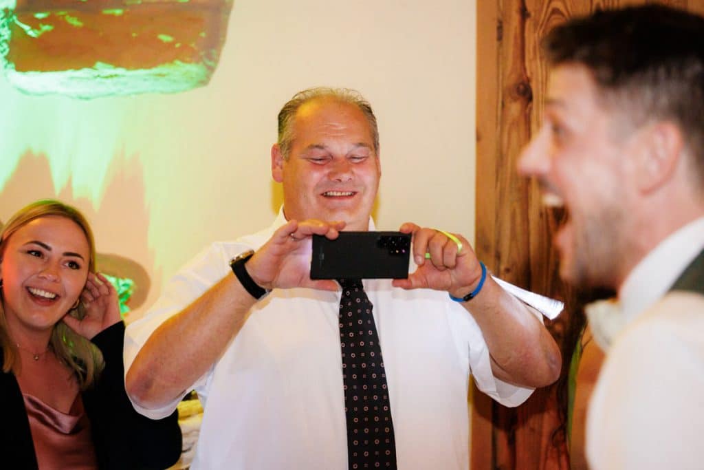 Lebhafte Hochzeitsfeier im Landgut Hochwald in Sonsbeck: Das Brautpaar tanzt ausgelassen mit Familie und Freunden, die Stimmung ist voller Freude und Energie. Die festlich dekorierte Location bietet den perfekten Rahmen für eine unvergessliche Feier, fotografiert vom Hochzeitsfotograf Niederrhein.