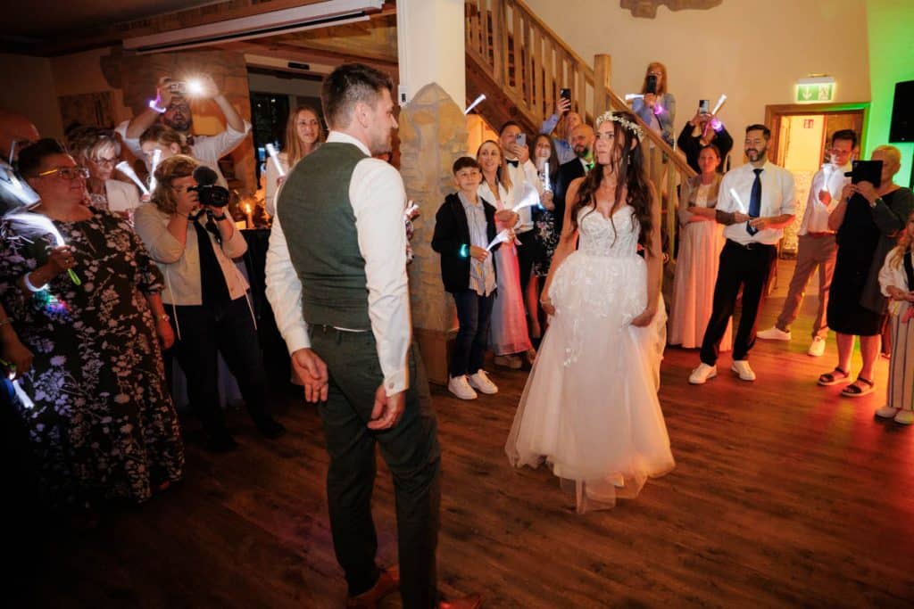 Lebhafte Hochzeitsfeier im Landgut Hochwald in Sonsbeck: Das Brautpaar tanzt ausgelassen mit Familie und Freunden, die Stimmung ist voller Freude und Energie. Die festlich dekorierte Location bietet den perfekten Rahmen für eine unvergessliche Feier, fotografiert vom Hochzeitsfotograf Niederrhein.