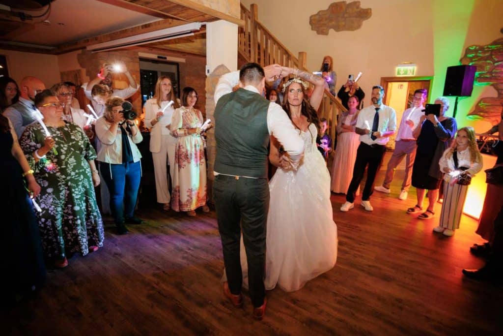 Lebhafte Hochzeitsfeier im Landgut Hochwald in Sonsbeck: Das Brautpaar tanzt ausgelassen mit Familie und Freunden, die Stimmung ist voller Freude und Energie. Die festlich dekorierte Location bietet den perfekten Rahmen für eine unvergessliche Feier, fotografiert vom Hochzeitsfotograf Niederrhein.
