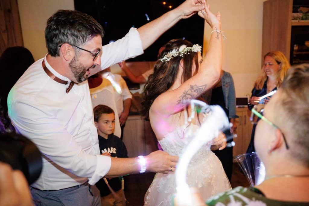 Lebhafte Hochzeitsfeier im Landgut Hochwald in Sonsbeck: Das Brautpaar tanzt ausgelassen mit Familie und Freunden, die Stimmung ist voller Freude und Energie. Die festlich dekorierte Location bietet den perfekten Rahmen für eine unvergessliche Feier, fotografiert vom Hochzeitsfotograf Niederrhein.