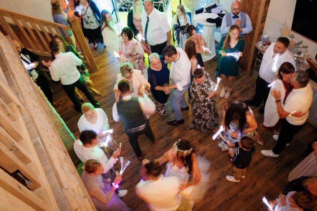 Lebhafte Hochzeitsfeier im Landgut Hochwald in Sonsbeck: Das Brautpaar tanzt ausgelassen mit Familie und Freunden, die Stimmung ist voller Freude und Energie. Die festlich dekorierte Location bietet den perfekten Rahmen für eine unvergessliche Feier, fotografiert vom Hochzeitsfotograf Niederrhein.
