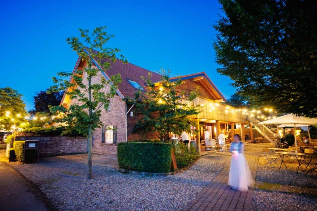 Lebhafte Hochzeitsfeier im Landgut Hochwald in Sonsbeck: Das Brautpaar tanzt ausgelassen mit Familie und Freunden, die Stimmung ist voller Freude und Energie. Die festlich dekorierte Location bietet den perfekten Rahmen für eine unvergessliche Feier, fotografiert vom Hochzeitsfotograf Niederrhein.