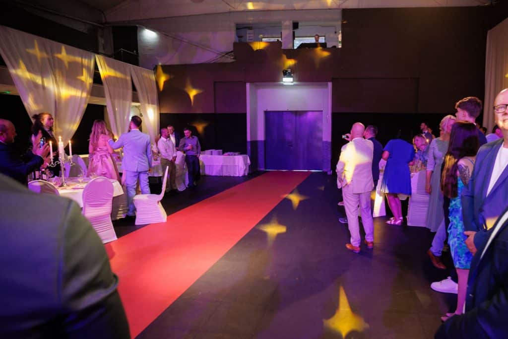 Ausgelassene Hochzeitsfeier im Resonanzwerk Oberhausen: Das Brautpaar eröffnet den Tanz, Gäste feiern ausgelassen auf der Tanzfläche und genießen das festliche Ambiente. Lebendige Reportagebilder voller Emotionen, aufgenommen vom Hochzeitsfotograf Duisburg.