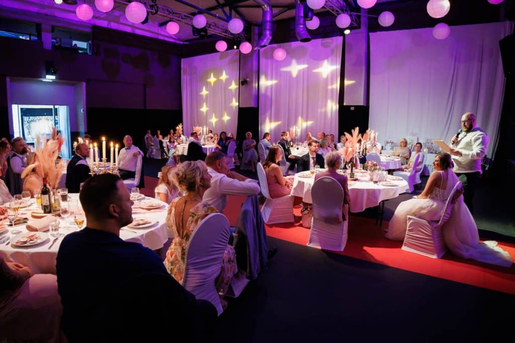 Ausgelassene Hochzeitsfeier im Resonanzwerk Oberhausen: Das Brautpaar eröffnet den Tanz, Gäste feiern ausgelassen auf der Tanzfläche und genießen das festliche Ambiente. Lebendige Reportagebilder voller Emotionen, aufgenommen vom Hochzeitsfotograf Duisburg.